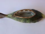 a small fish shaped teapot with a gold rim