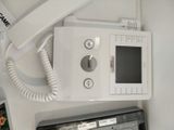 a white telephone sitting on top of a desk next to a laptop