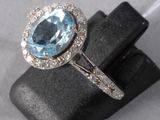 gros plan d'une bague avec une topaze bleue entourée de diamants