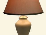 une lampe posée sur une table, avec un abat-jour marron