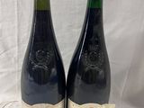 deux bouteilles de vin posées l'une à côté de l'autre sur une table