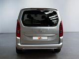 the back of a silver van is parked in a room