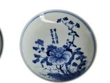 three blue and white plates with flowers on them on a white surface