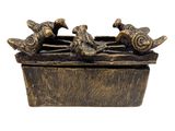 une statue en bronze représentant des oiseaux perchés sur une boîte en bois