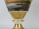 a vase with a painting on it sitting on a stand