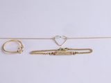 three pieces of gold jewellery on a white surface