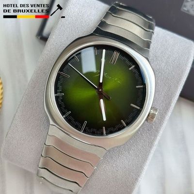 someone is holding a watch with a green face on it