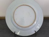a white plate with a gold rim on a stand
