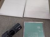 une photo d'une chambre avec un lit et un cadre photo posé par terre