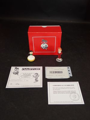 une boîte rouge posée sur une table, contenant une petite figurine