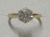 une bague sertie d'un diamant, posée sur une table