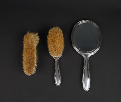 two brushes and a mirror on a black surface