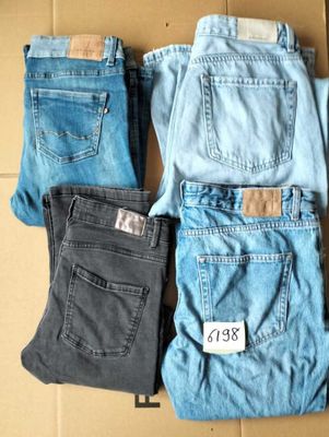 several pairs of jeans are sitting on a cardboard box