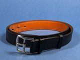a close up of a black and orange belt on a blue surface