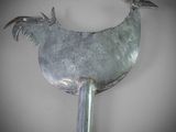 a metal fan with a bird on top of it