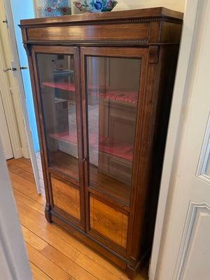 un meuble en bois avec des portes en verre dans une pièce