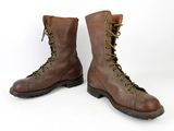 pair of brown boots with green laces on them on a white surface