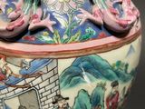 a vase with a painting on it sitting on a table