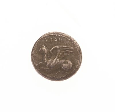 une vieille pièce de monnaie sur laquelle figure un dragon, sur un fond blanc