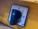 a close up of a button on the side of a yellow truck
