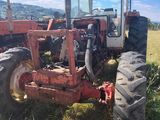 a tractor that is sitting in the grass in the field
