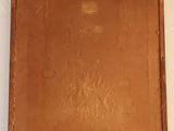 an old brown box sitting on top of a white sheet