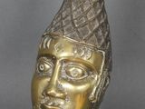 tête de femme en bronze, ornée d'une plume sur la tête