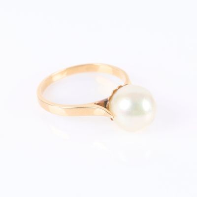 une bague en or ornée d'une perle blanche