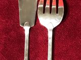 deux fourchettes et un couteau posés sur une nappe rouge