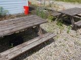 deux tables de pique-nique et une poubelle devant une maison bleue