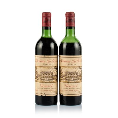 two bottles of wine sitting next to each other on a white surface