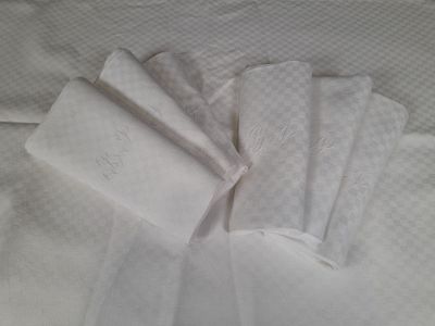 four white napkins on top of a white bed