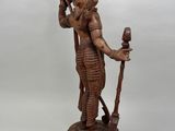 an image of a wooden statue of a man holding a staff