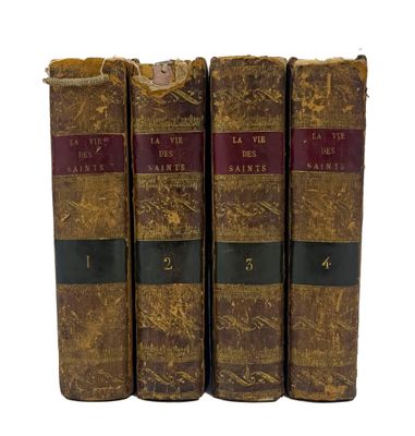 trois vieux livres posés l'un sur l'autre sur une surface blanche