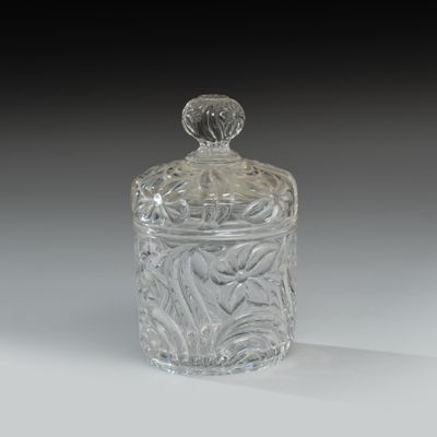 un pot en verre transparent avec un couvercle sur une table