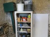 a cabinet with a door that is open in the corner of a room