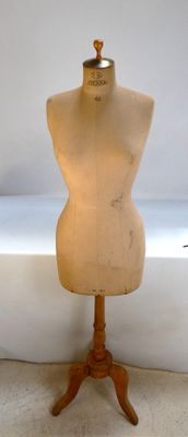 a mannequin on a wooden stand in front of a window