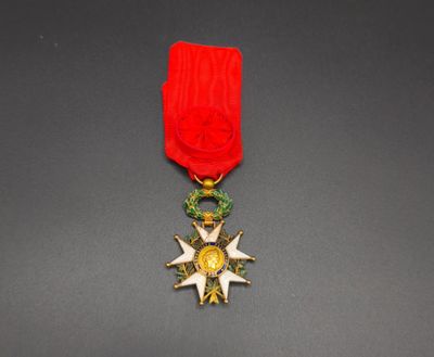 a close up of a medal on a table with a red ribbon