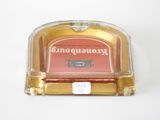 a glass ashtray with a red label on it