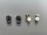 three pairs of black and white pearl earrings on a black surface