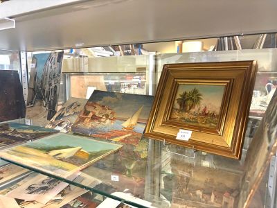 une vitrine en verre ornée de tableaux, dans un musée