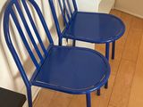 two blue chairs sitting next to each other on a wooden floor
