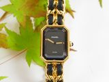 an image of a black and gold watch sitting on top of a table
