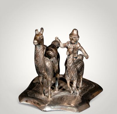 statue of a man and a woman riding a camel on a plate