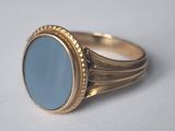 Gros plan sur une bague en or ornée d'une pierre bleue