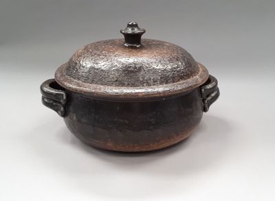 an image of a brown pot with a lid sitting on a white surface