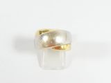 gros plan d'une bague en or et en argent sur une surface blanche