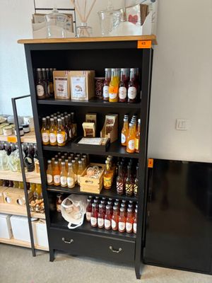 une étagère noire sur laquelle sont posés des bouteilles et des bocaux contenant des aliments