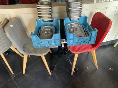 Plusieurs chaises, sur lesquelles sont posés des plateaux-repas, sont alignées en rangée