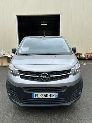 the front of a silver van parked in front of a building